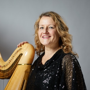 Frau hält Harfe fest